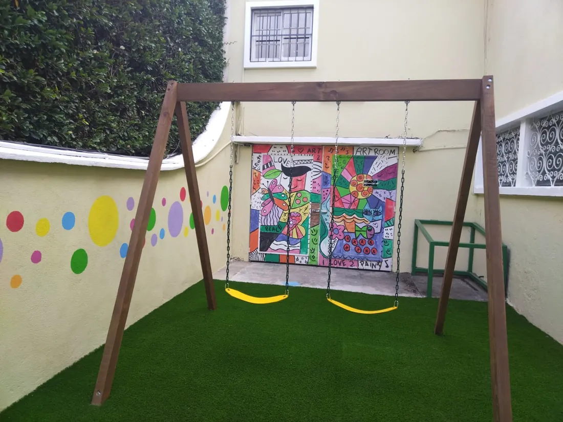 Columpios de madera para niños: viga con dos columpios instalada en un jardín en Guatemala